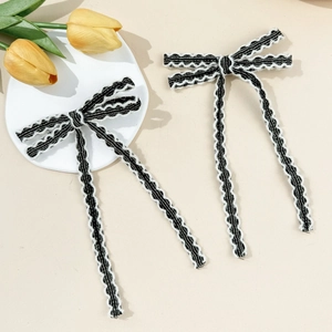 Gros plan de barrettes à nœuds en dentelle noir et blanc avec de longs rubans style français