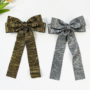 Detail view of gold and silver metallic crinkle fabric bow hairclips with long ribbons