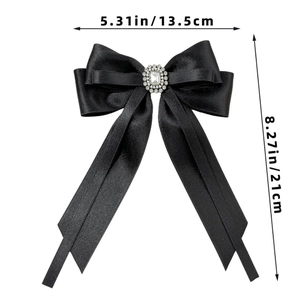 Detail view of large black satin bow hair clip with luxury rhinestone centerpiece decor
