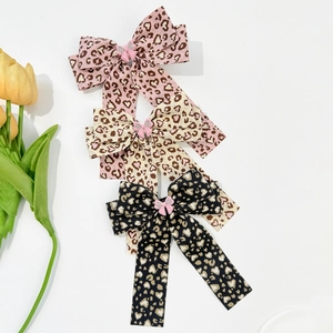 Three-piece set of leopard print bow hair clips with heart patterns and crystal details