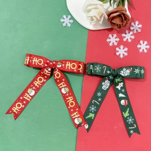 Dettaglio di fiocchi natalizi rossi e verdi con motivi di Babbo Natale e fiocchi di neve
