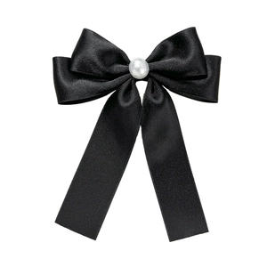 Barrette à nœud en satin noir élégante avec perle centrale sur un fond blanc neutre