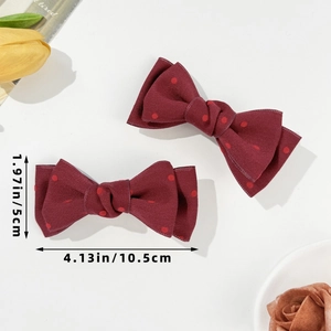 Nahaufnahme roter gepunkteter Schleifen-Haarclips mit Maßen 10,5cm x 5cm auf Weiß