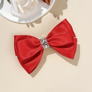 Vue détaillée du grand nœud papillon en satin rouge avec centre en strass luxueux