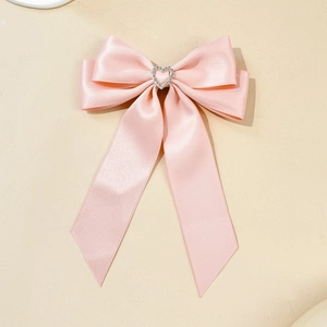 Fermaglio a fiocco in raso rosa con strass a cuore traforato per acconciatura elegante