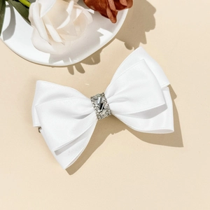 Gros plan d'un nœud papillon en satin blanc élégant avec centre luxueux en strass brillants