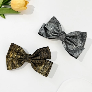 Metallic crinkled bow hair clips in gold and silver finish with textured fabric style