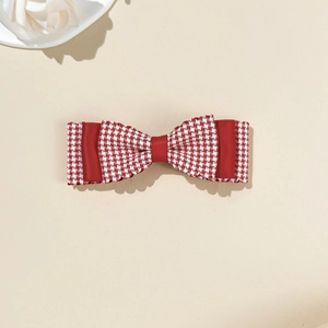 Detailed macro view of a red and white gingham bow hair clip with tiered satin layers