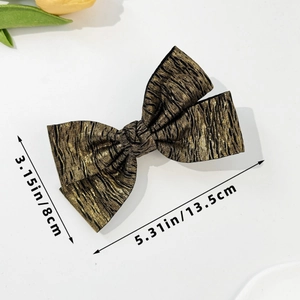 Detailed view of large vintage bow hair clip showing fabric texture and 13.5cm size
