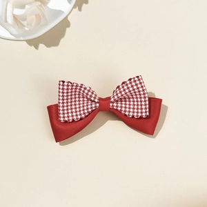 Detail of red and white checkered bow hair clip with lace edges and satin ribbon base