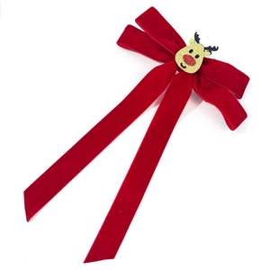 Nahaufnahme der roten Samt-Schleife mit goldenem Glitzer-Rentier für Weihnachten