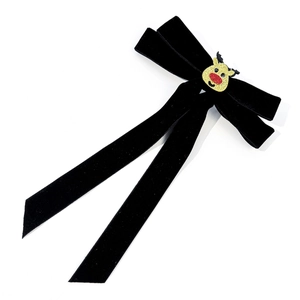 Detailaufnahme einer schwarzen Weihnachts-Samtschleife mit goldenem Glitzer-Rentier