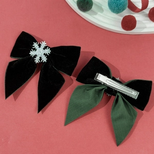 Dettagli di fiocchi natalizi in velluto verde con fiocco di neve e clip a coccodrillo in metallo