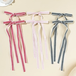 Three ballet-style plaid ribbon bow hair clips in red, pink, and black colors