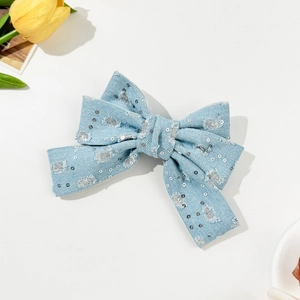 Dettaglio fiocco per capelli in denim azzurro con paillettes argento e bordi sfrangiati