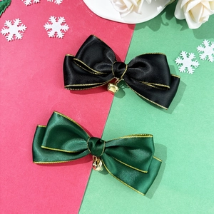 Detail of Christmas ribbon hair clips with gold edges and small metal bells