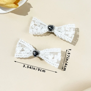 Vue détaillée de barrettes nœuds en dentelle blanche avec strass cœur et dimensions