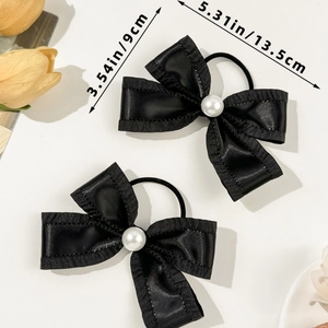 Detail view of black satin bow hair ties with lace trim, pearl center and size markings