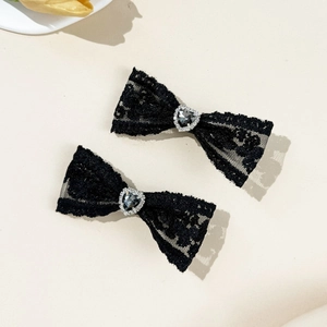Gros plan de barrettes à nœud en dentelle noire avec cœur serti de strass