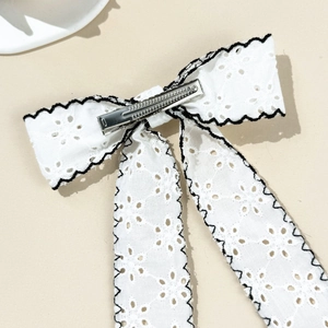 Detailed view of the white lace bow hair clip featuring a metal crocodile clip back