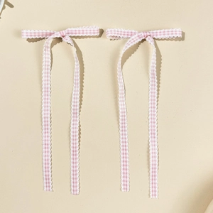 Detail of pink plaid ballet-style long ribbon bows with delicate scalloped wavy edges