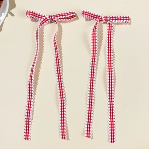Detail showing red and white plaid bow hair clips with delicate white lace trim