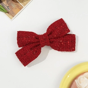Detail of red tweed bow hair clip with sequins and vintage style for women