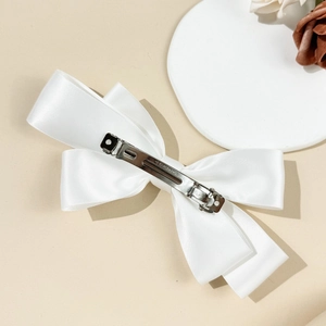 Detail of the elegant white satin bow hair clip with steel spring back and Clip Paris stamp