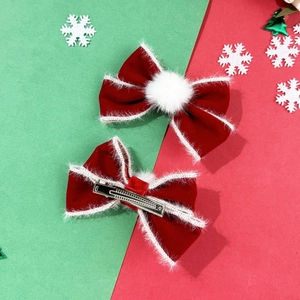 Detail der roten Weihnachtsschleifen aus Samt mit Kunstpelzbesatz und Metall-Haarklammer