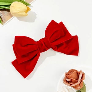 Dettaglio dell'elegante fermaglio per capelli in velluto rosso con fiocco a tre strati