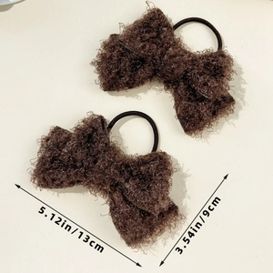 Detail view of two brown fluffy curly bow hair ties showing plush texture and dimensions