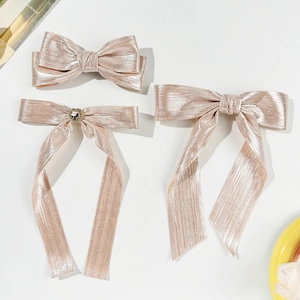Barrettes nœuds rose doré avec texture métallique et cristal en forme de cœur élégant