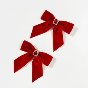 Close-up of red velvet bow hair clips with square ruby gemstone and crystal rhinestones