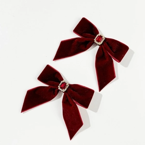 Detail of red velvet bow hair clips with rectangular ruby and crystal embellishments