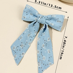 Detailed view of blue denim bow hair clip with silver sequins and size dimensions