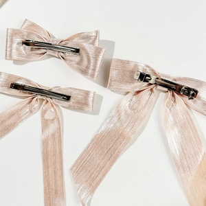 Barrettes à nœuds en ruban rose métallisé avec texture verticale et clips bec de canard