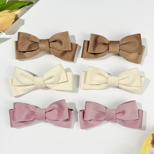 Sechser-Set Cord-Haarspangen mit Schleifen in Braun, Creme und Rosa auf weißem Grund