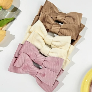 Drei Cord-Haarspangen mit Schleife in Braun, Beige und Lila auf weißem Hintergrund