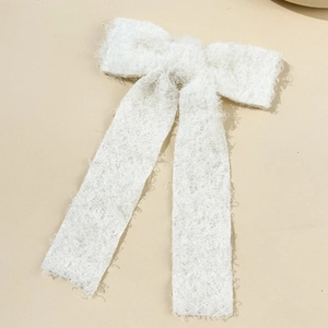 Elegant white teddy fleece bow hair clip with long ribbons on a cream background
