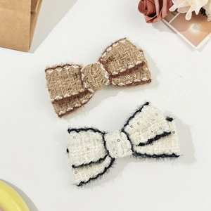 Elegant tweed bow hair clips with sequins in brown and white on a minimalist background