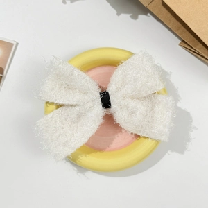 Gros plan d'une grande pince à cheveux en peluche blanche avec centre noir élégant