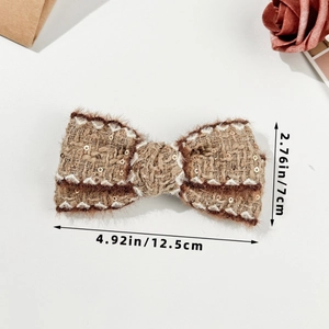 Detail view showing brown tweed bow hair clip with sequins and size dimensions in inches