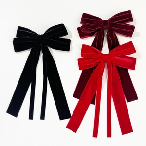 Three velvet bow hair clips in black, burgundy and red with long trailing ribbons