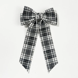 Detail of vintage plaid bow hair clip featuring woven fabric and delicate rhinestones