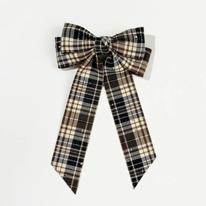 Close-up detail of British style tartan plaid bow hair clip with long ribbon tails