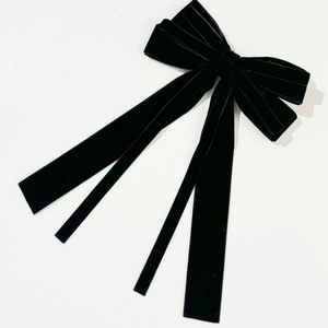Detailed view of layered black velvet bow hair clip with elegant long streamers