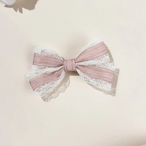 Macro view of pink silk ribbon and white floral lace detail on the sweet bow hairclip