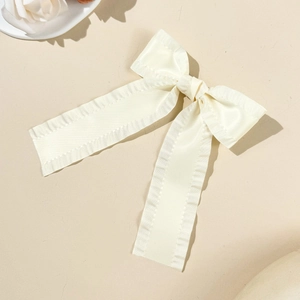 Gros plan sur un nœud papillon en soie crème avec bordure ondulée et rubans élégants