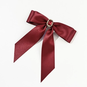 Vue détaillée du nœud en satin bordeaux avec une pierre précieuse rétro centrale