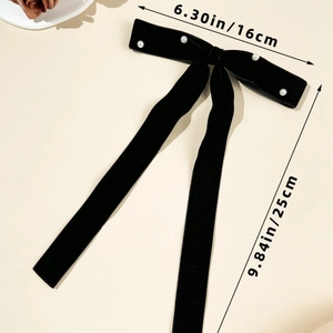 Detail view of a large black velvet bow hair clip with pearls, size 16cm by 25cm